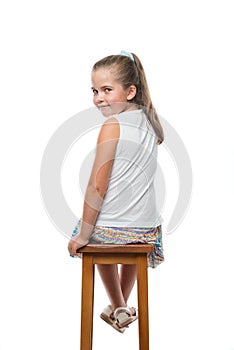 little girl sitting on chair looking back