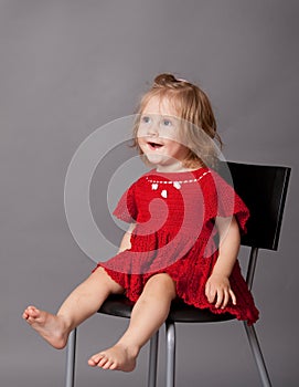 Little girl is sitting in chair in studio