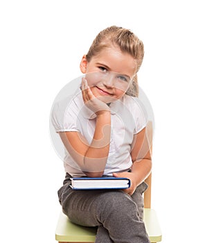 Little girl sitting on a chait with book on the knee