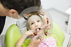 Little girl sitting on dental chair