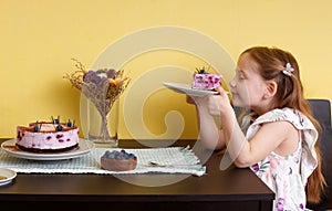 Little girl sitting at the dining table with a slice of blueberry cheesecake dessert.