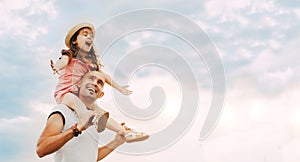 Little girl sitting on father`s shoulders