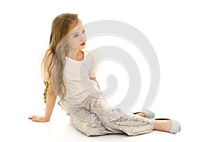 Little girl is sitting on the floor.The concept of a happy child