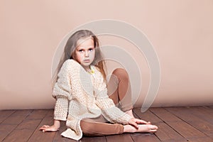 Little girl sitting on the floor and sad