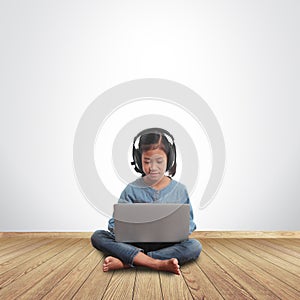 Little girl sitting on the floor with using laptop computer