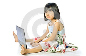 Little girl sitting on floor using a laptop