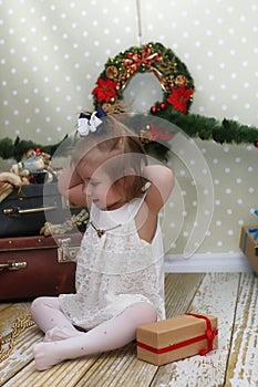 Little girl sitting in front of a Christmas tree