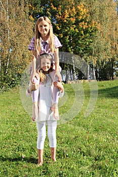 Little girl sitting on girlsÂ´ shoulders