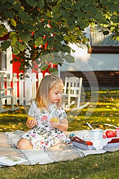 The little girl sitting on green grass