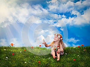 Little girl sitting on green grass and squinting in the sun. The child keeps on hand a butterfly and a bouquet of flowers.