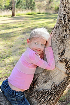 Little girl sitting in a gum tree