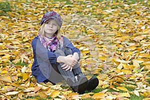 Little girl sitting on leaves
