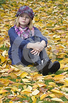 Little girl sitting on leaves