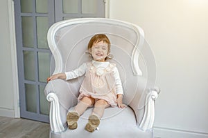 Little girl sitting on modern chair