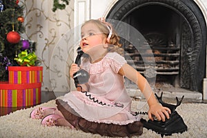 Little girl sitting next to a vintage  telephone