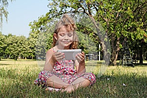 Little girl sitting play with tablet