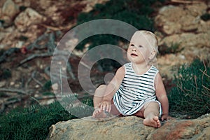 Little girl sitting on rock, outdoor