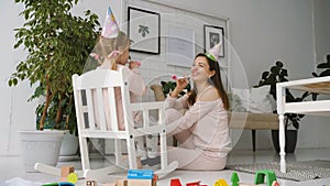 Little girl sitting in rocking chair and play with mother