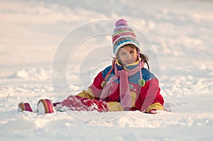 Little girl sitting on the snow photo