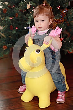 Little girl sitting on toy donkey