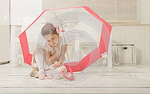 Little girl sitting under an umbrella