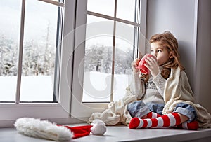 Little girl sitting by the window