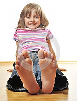 Little girl sitting on a wooden floor