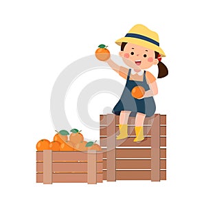 Little girl sitting on wooden nearby boxes with the harvest of the oranges