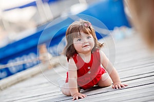Little girl sitting on a wooden pier