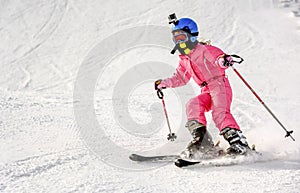 Little girl skiing fast downhill