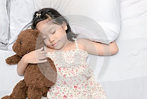 Little girl sleep with teddy bear on bed