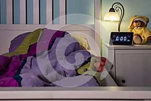 Little girl sleeping in bed - Alarm clock at 6 am in the morning.