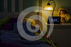 Little girl sleeping in bed - Alarm clock at 6 am in the morning.