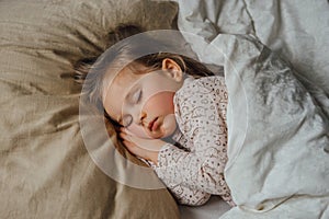 Little girl sleeping in bed at home, top view