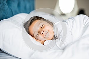 Little girl sleeping in bed peacefully in her bright lit room