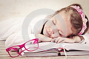 Little girl sleeping on the books