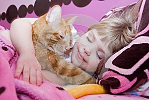 little girl sleeping with cat in bed