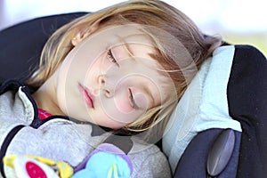 Little girl sleeping on children car safety seat