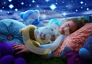 Little girl sleeping with teddy bear in bed, dreaming the starry sky at bedtime night photo