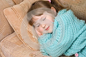 The little girl sleeps on a sofa photo