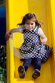 Little girl slides in playground