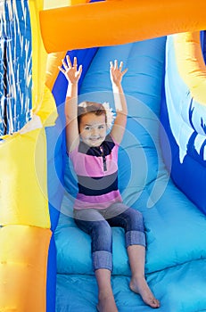 Little Girl sliding down an inflatable Slide