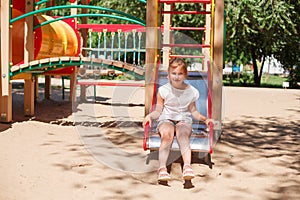 Little girl is sliding at playground