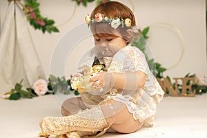 little girl smashes a cake on his first birthday. Smash cake, stylized photo session for a children& x27;s party