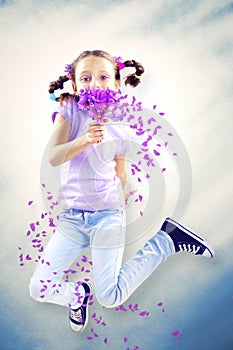 Little girl smelling flower on air in spring time
