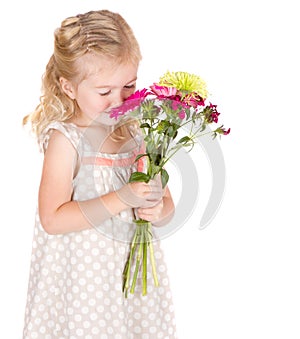 Little girl smelling flowers