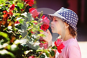 Little girl smelling  roses