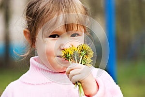 The little girl smells flowers