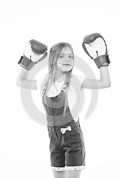 Little girl smile after boxing training isolated on white. Happy child raised hands in boxing gloves. Punching