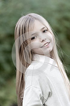 Little girl smile with long blond hair. Child with cute face outdoor. Beauty kid with fresh look and skin. Beauty look